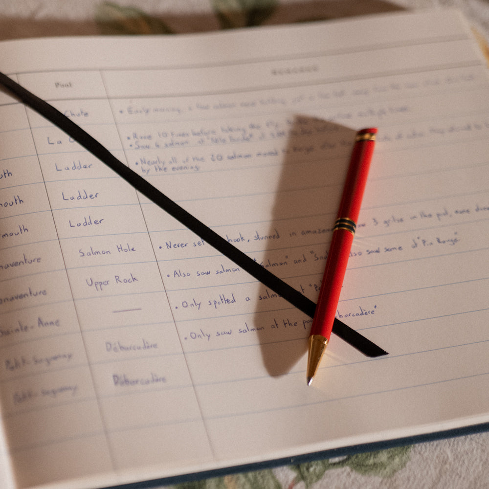 Interior pages of the Atlantic Salmon Log showing fields to record fly, river, and conditions with a red pen.