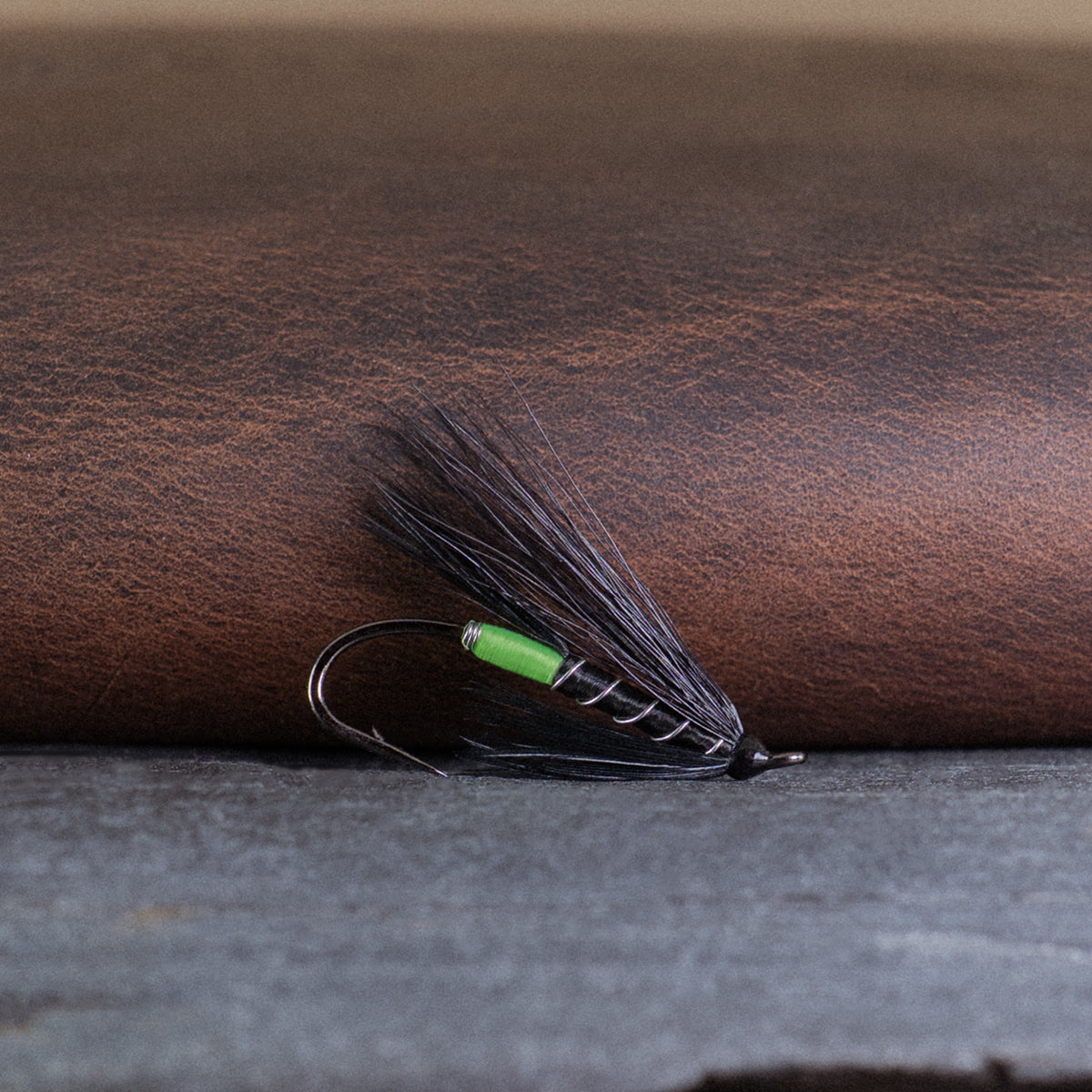 An Atlantic salmon fly named the Black Bear Green Butt that is popular in Québec and Eastern Canada for Atlantic salmon fly fishing, tied here on a single hook.