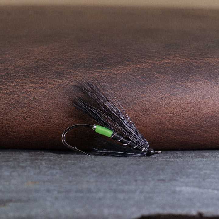 An Atlantic salmon fly named the Black Bear Green Butt that is popular in Québec and Eastern Canada for Atlantic salmon fly fishing, tied here on a single hook.