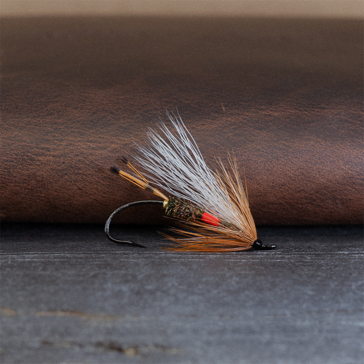 An Atlantic salmon fly named the Royal Coachman that is popular for Atlantic salmon, trout, and steelhead fly fishing, tied here on a single hook.
