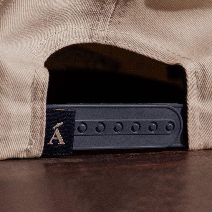 Close-up of a cap with a brand logo on a wooden surface