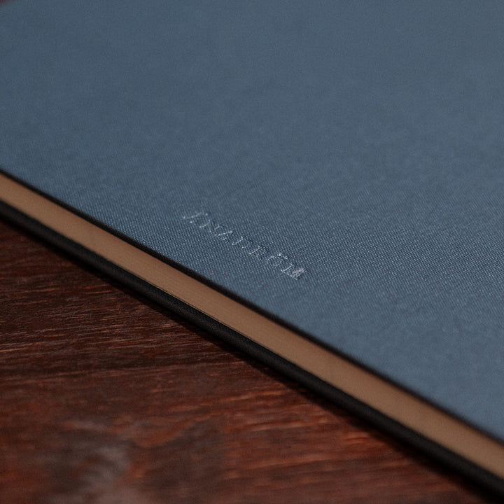 Close up image of the back cover of the Atlantic Salmon Log on a vintage wooden desk.