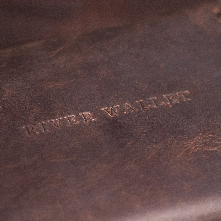 Close-up of the front logo on the Explorer Fly Wallet, embossed into full-grain leather
