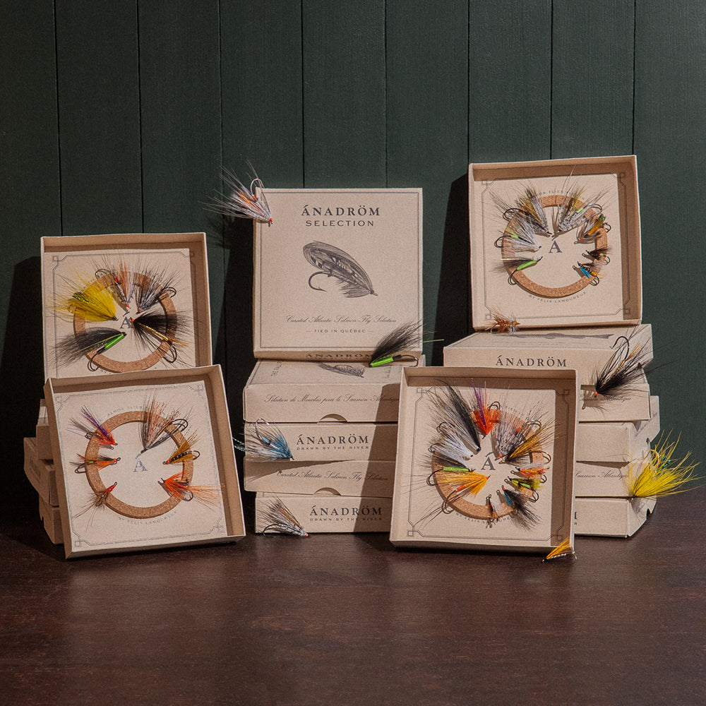 Ánadröm fly box collection arranged on dark wood surface, four open boxes showing hand-tied Quebec salmon flies.