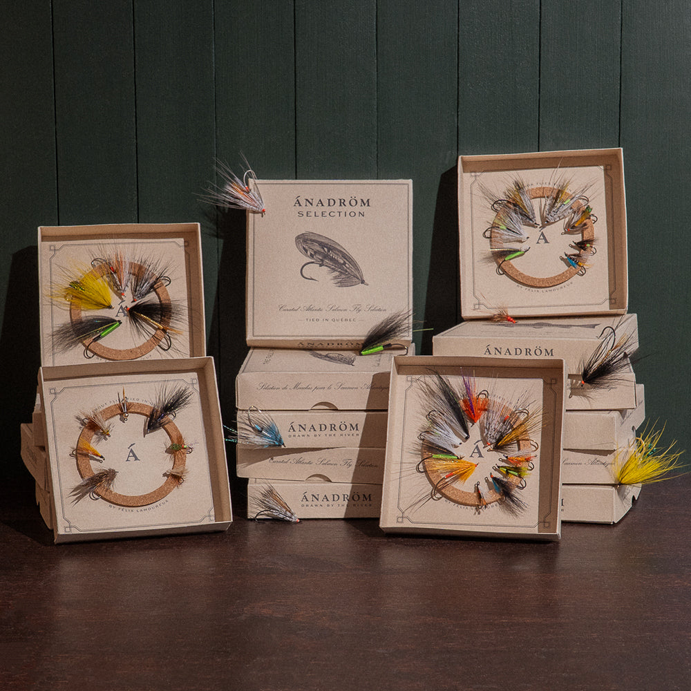 Multiple open Ánadröm fly boxes stacked, displaying curated Atlantic salmon and brook trout selections.