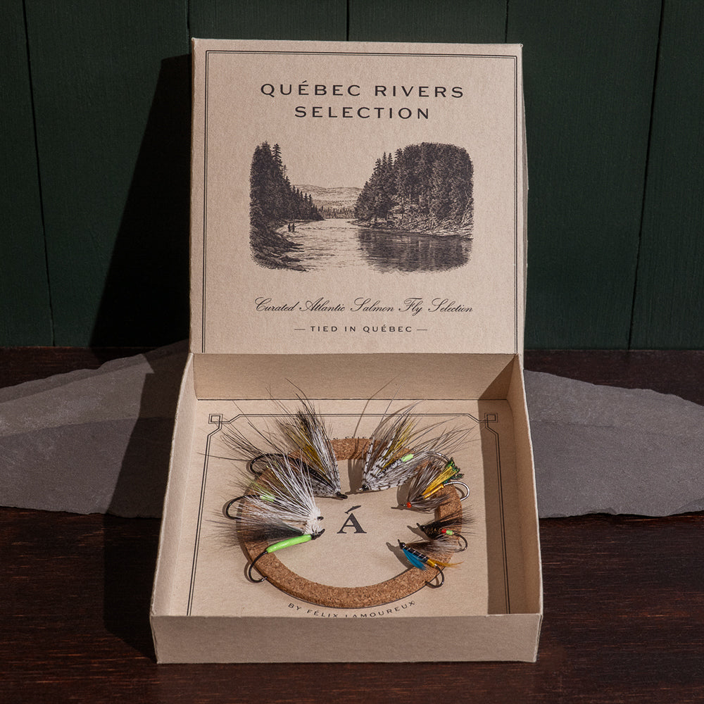 Ánadröm Québec Rivers Selection box open, seven hand-tied Atlantic salmon flies on cork insert, river engraving on lid.